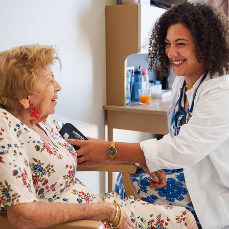 une soignante mesure la tension artérielle d'une résidente